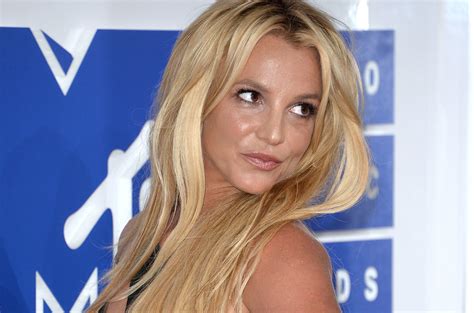 Britney Spears Frolics Topless on the Beach in New Video:。